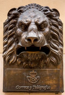 Tourist group in front of a bronze letterbox in the shape of a lion, Correos y Telegraficos, La