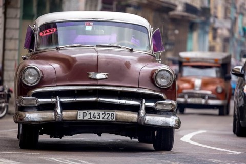 Brown vintage car in street scene, Old American street cruiser on the streets of Havana, taxi, La