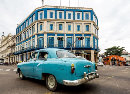Turquoise-coloured vintage car in street scene, Old American street cruiser on the streets of