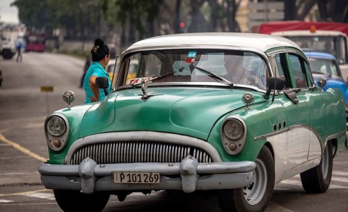 Green vintage car in street scene, Old American street cruiser on the streets of Havana, Taxi, La