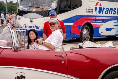 Tourists in a red convertible, red vintage convertible in the street scene, old American road