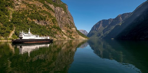 Excursion ship on a fjord, Flåm, Gudvangen, rock walls, trees, blue sky, Sogn og Fjordane, Norway,