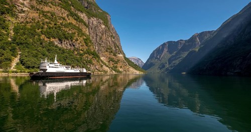 Excursion ship on a fjord, Flåm, Gudvangen, rock walls, trees, blue sky, Sogn og Fjordane, Norway,