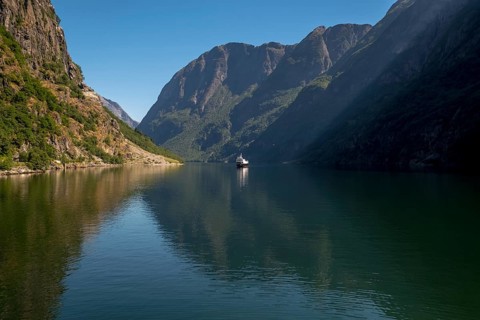 Excursion ship on a fjord, Flåm, Gudvangen, rock walls, trees, blue sky, Sogn og Fjordane, Norway,