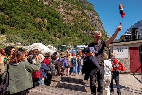 Travel guide with mascot at mountain hut station, mountains, construction site, construction site