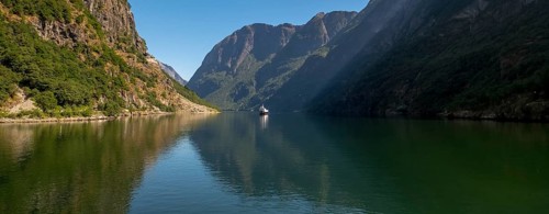 Excursion ship on a fjord, Flåm, Gudvangen, rock walls, trees, blue sky, Sogn og Fjordane, Norway,