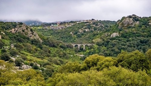 Sardinia, rugged granite mountains of Gallura, quarries and viaduct in hilly landscape, Olbia,