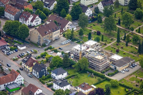 Aerial view, construction site with new building on the main road at the cemetery, left Städt. Kita