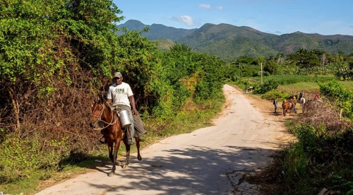 Cuban rider on a horse with a milk can in Valle de los Ingenios, Trinidad, Cuba, Sancti Spíritus,