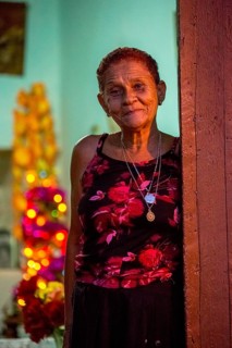 Old lady looks friendly out of her front door, Street scene in the old town of Trinidad, Trinidad,
