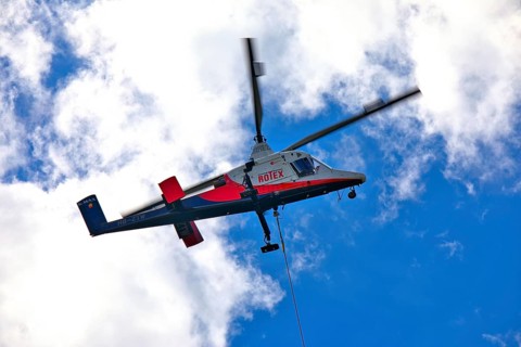 Helicopter moving in the cloudy sky, transport helicopter, timber transport, Saas Grund, Canton