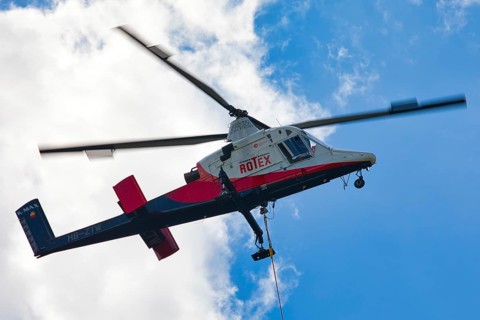 Detailed view of a helicopter with Rotex logo in the sky, transport helicopter, timber transport,