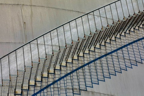 Close-up of a metal staircase with detailed shadows on the tank surface, elevated tank, chemical,