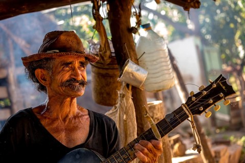 Sugar cane farmer in Valle de los Ingenios plays guitar for the tourists, Trinidad, Cuba, Sancti