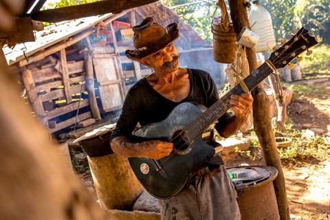 Sugar cane farmer in Valle de los Ingenios plays guitar for the tourists, Trinidad, Cuba, Sancti