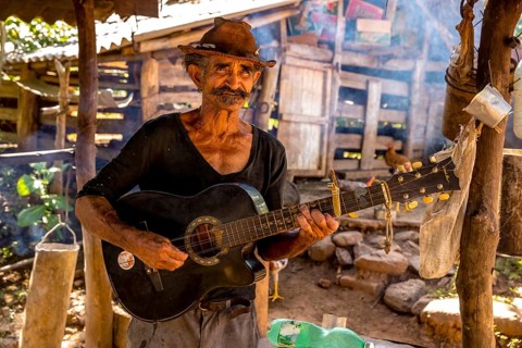 Sugar cane farmer in Valle de los Ingenios plays guitar for the tourists, Trinidad, Cuba, Sancti