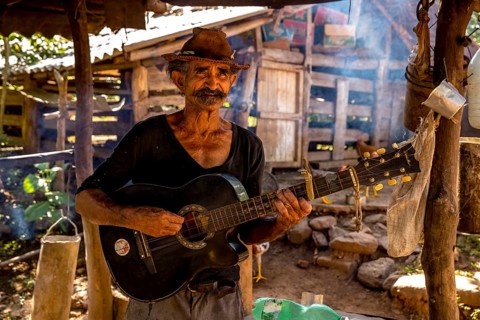 Sugar cane farmer in Valle de los Ingenios plays guitar for the tourists, Trinidad, Cuba, Sancti