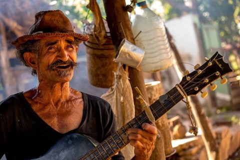 Sugar cane farmer in Valle de los Ingenios plays guitar for the tourists, Trinidad, Cuba, Sancti