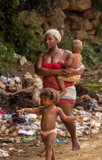 Mother with two children barefoot at a rubbish dump, poverty on the island of Cuba, Trinidad, Cuba,