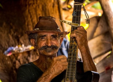 Sugar cane farmer in Valle de los Ingenios plays guitar for the tourists, Trinidad, Cuba, Sancti
