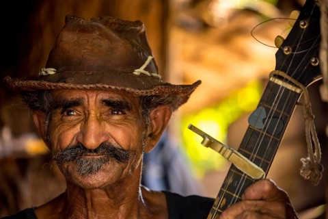 Sugar cane farmer in Valle de los Ingenios plays guitar for the tourists, Trinidad, Cuba, Sancti