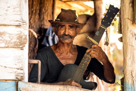 Sugar cane farmer in Valle de los Ingenios plays guitar for the tourists, Trinidad, Cuba, Sancti
