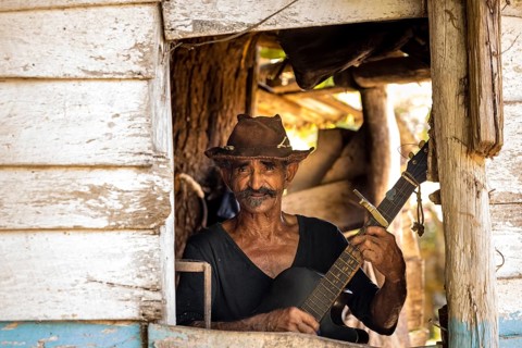 Sugar cane farmer in Valle de los Ingenios plays guitar for the tourists, Trinidad, Cuba, Sancti