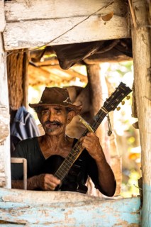 Sugar cane farmer in Valle de los Ingenios plays guitar for the tourists, Trinidad, Cuba, Sancti