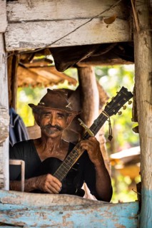Sugar cane farmer in Valle de los Ingenios plays guitar for the tourists, Trinidad, Cuba, Sancti