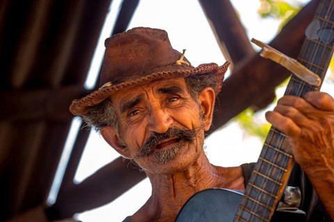 Sugar cane farmer in Valle de los Ingenios plays guitar for the tourists, Trinidad, Cuba, Sancti