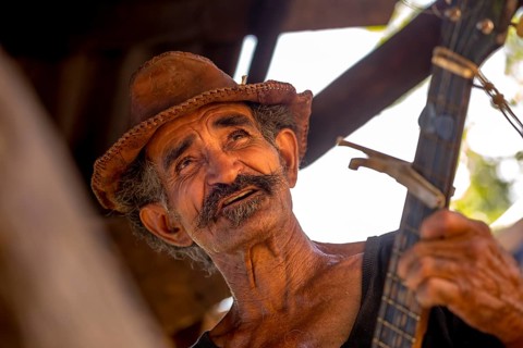 Sugar cane farmer in Valle de los Ingenios plays guitar for the tourists, Trinidad, Cuba, Sancti