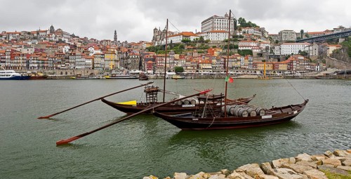 Historic wine transport ships on the Douro, colourful houses on the banks of the Douro in the