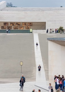Penitents slide on their knees across the forecourt of the Basilica of Fatima, Fátima, District of