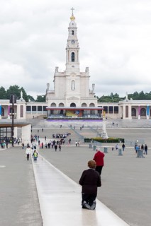 Penitents slide on their knees across the forecourt of the Basilica of Fatima, Fátima, District of