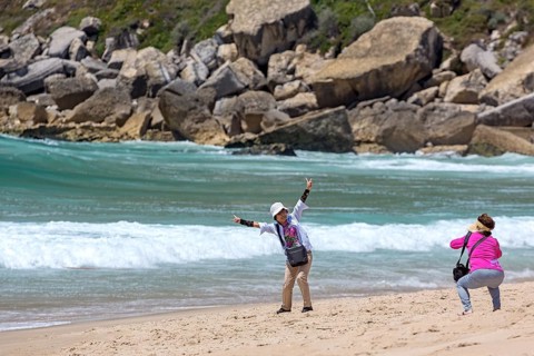 Japanese tourists photographing themselves on the beach of Nazare, Nazaré, Leiria district,