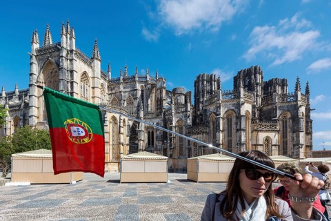Travel guide in front of the monastery, Monastery of Santa Maria da VitÃüria, UNESCO World Heritage