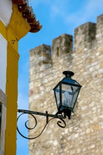 Picturesque small town Obidos, street lamp in front of city wall, Ãbidos, district Leiria,