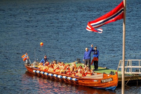 Norwegian flag, river cruise with tourists on an excursion boat, boat guide, Kirkenes, Finnmark,