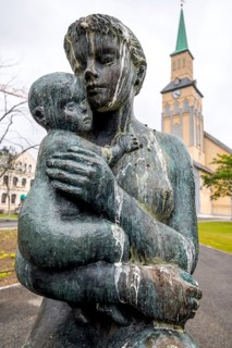 Statue Mother and Child, Church Square, Tromsø Cathedral in the background, Tromsø, Troms, Norway,