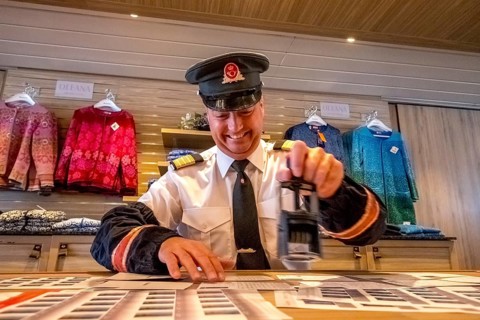Crew member stamps the mail on the mailboat, postman, ship officer, postal employee, postcard
