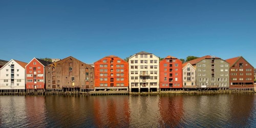 Warehouse city, picturesque colourful houses and commercial buildings on the river Nidelva, pile