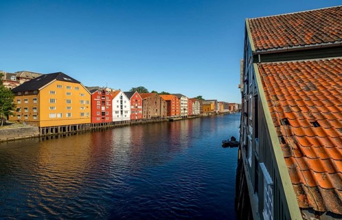 Warehouse city, picturesque colourful houses and commercial buildings on the river Nidelva, pile