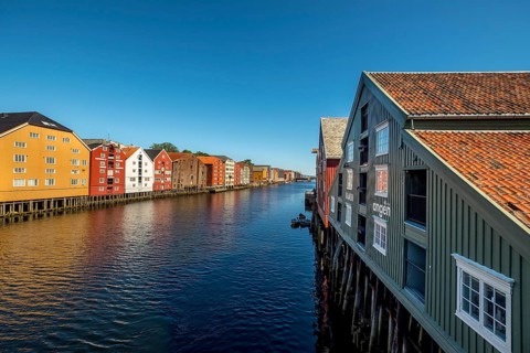 Warehouse city, picturesque colourful houses and commercial buildings on the river Nidelva, pile