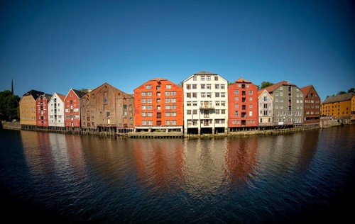 Warehouse city, picturesque colourful houses and commercial buildings on the river Nidelva, pile
