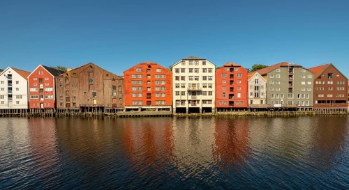 Warehouse city, picturesque colourful houses and commercial buildings on the river Nidelva, pile