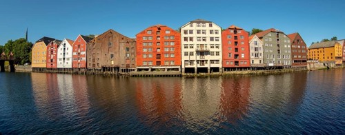 Warehouse city, picturesque colourful houses and commercial buildings on the river Nidelva, pile