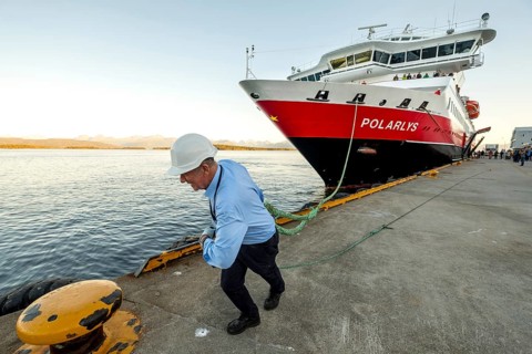 Sailor, sailor mooring the ship MS Polarlys at the quay, harbour bollard with mooring line, Molde