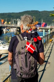 Tourist with backpack and cloth cup and Norwegian flag, travel guide, tour guide, tourist guid,
