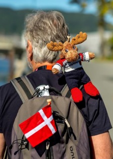 Tourist with backpack and cloth cup and Norwegian flag, travel guide, tour guide, tourist guid,