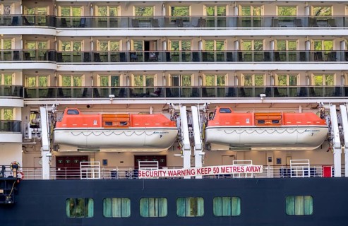 Ship RMS Queen Elizabeth, warning to sea pirates, security warning keep 50 metres away, lifeboats,